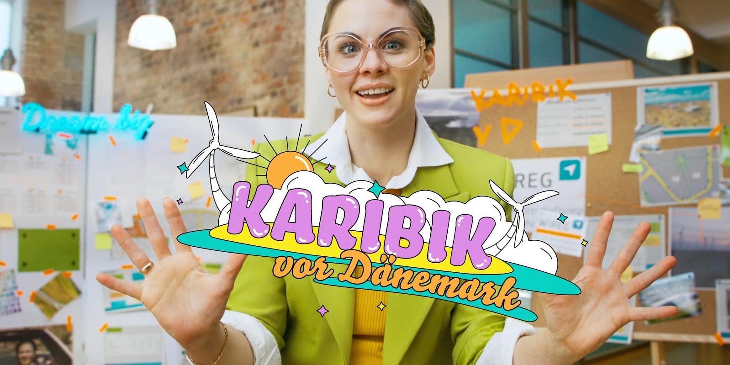 Eine schrill bunt gekleidete Frau mit kurzen Haaren und Brille schaut aufgeregt direkt in die Kamera. Zwischen ihren Händen steht illustriert "Die Karibik vor Dänemark".